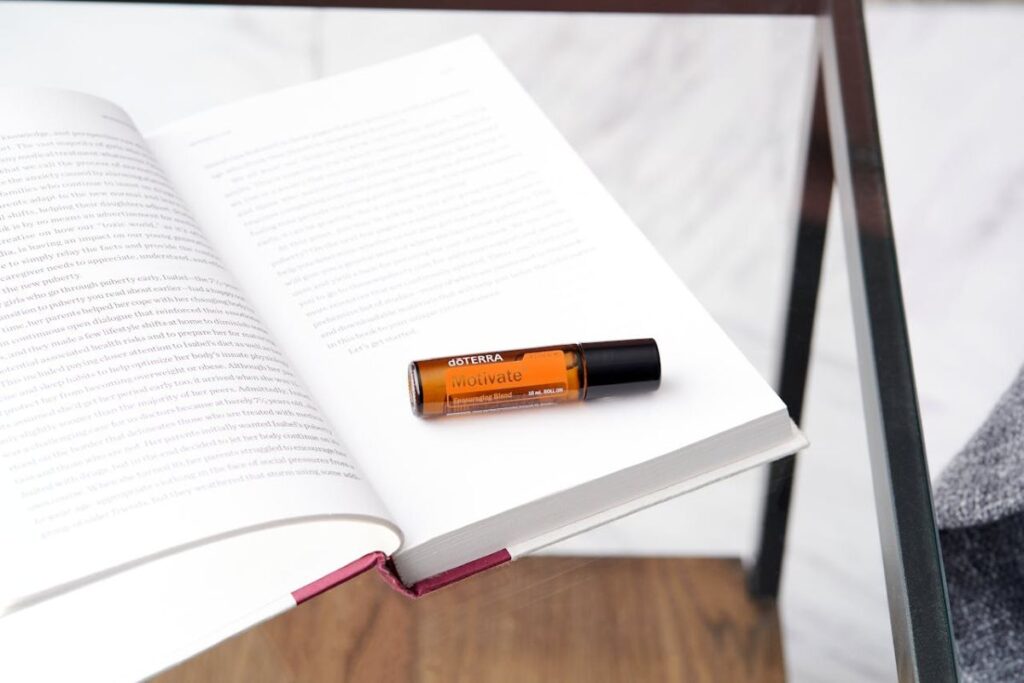 Motivate Roller der Firma doTerra im Alltag, in einem Buch liegend.